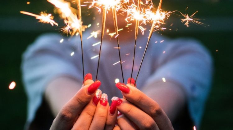 Woman holding fire crackers- 4th of july nail designs | Nail Art | 4th of July nails American Flag-Inspired Nail Design | Featured