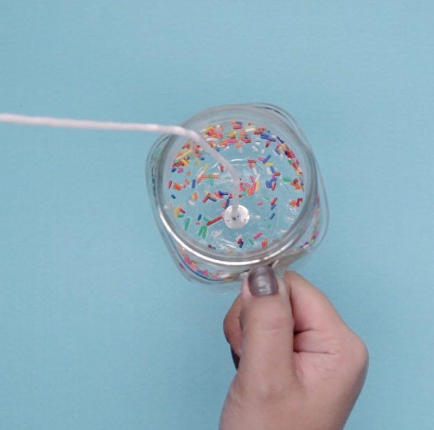 Step 3: Hold the jar horizontally and add a spoonful of sprinkles. | Fun & Festive DIY! Make Your Own Funfetti Candle