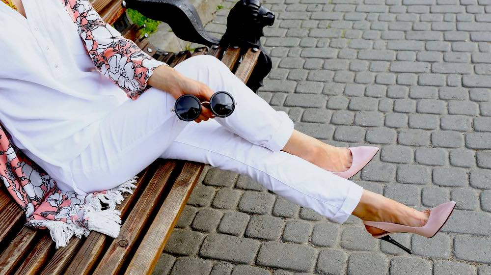 Woman Sitting on Bench | 12 Chic Ways To Wear Your White Jeans | Featured