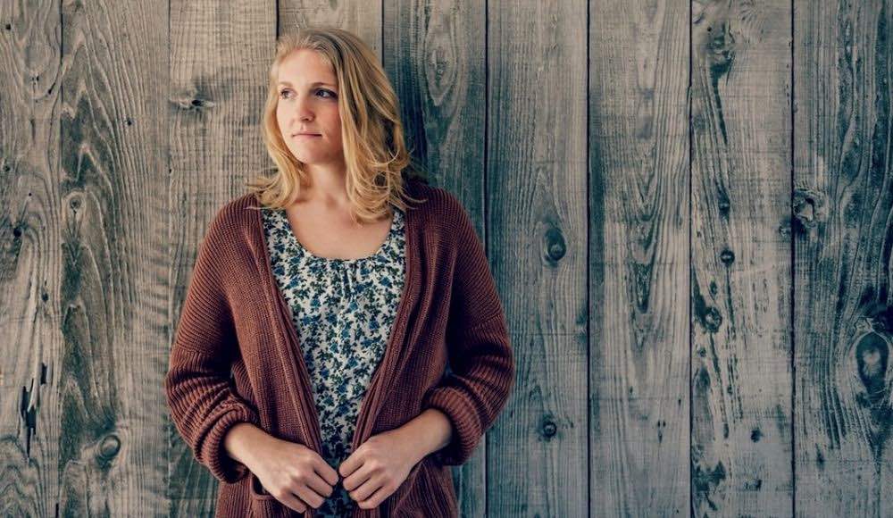 woman wearing brown cardigan leaning on wooden wall | Cute Casual Outfits For The Colder Weather