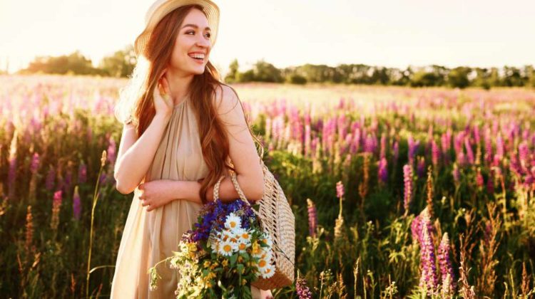 Happy young girl walking in flower field at sunset | Hottest Spring Colors To Wear That Aren’t Pastel | spring colors clothes | Featured