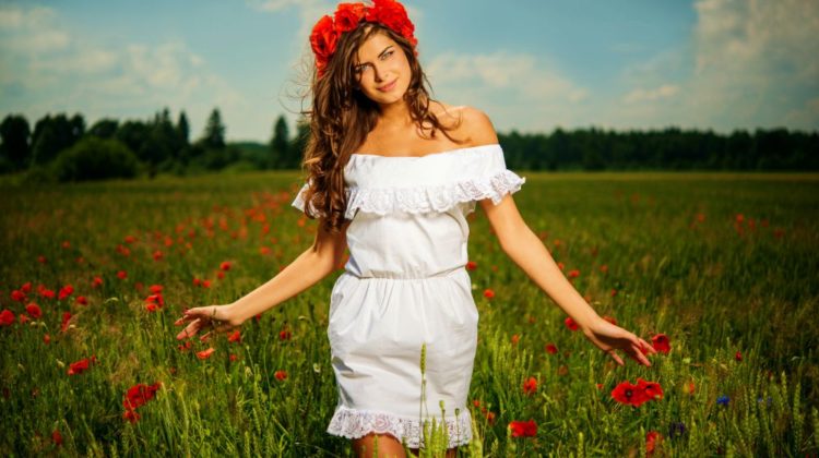 Beautiful young brunette girl wearing white summer dress and flower chaplet in poppy filed | Cinco de Mayo Outfits To Lift Up Your Spirits At Home | cinco de mayo attire party | Featured
