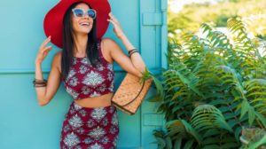 Stylish beautiful woman in red hat posing on blue background | Must-Have Sexy Summer Outfits For A Sizzling Summer | sexy summer outfits | summer hats | Featured