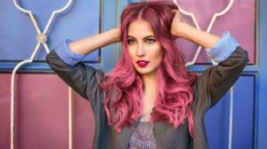 Beautiful hipster fashion model with curly pink hair posing in front of the colorful wall | Best shampoo and conditioner for colored hair | Best Shampoo For Colored Hair To Keep Its Color Vibrant | Cute Outfits | Featured