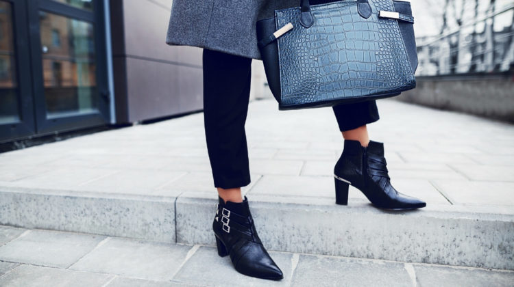 Fashionable woman posing in street, holding big dark blue textured bag, wearing stylish pointed toe ankle boots, elegant clothes-ss-feature | 13 Ways To Style Leather Ankle Boots