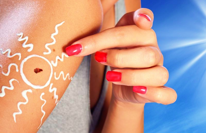 Melanoma skin cancer on woman arm with sun in the background | Benefits Of Sunscreen Spray You Should Know Before Heading Out | baby sunscreen