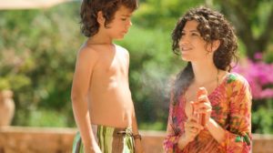 Mother spraying sunscreen on son | Benefits Of Sunscreen Spray You Should Know Before Heading Out | tinted sunscreen | Featured