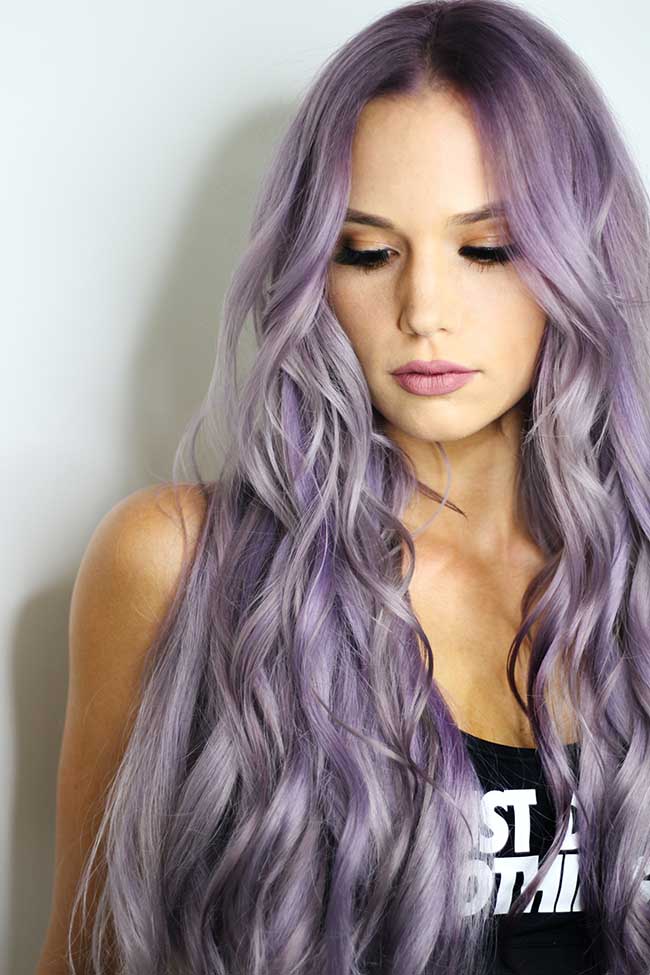 purple haired woman in black top leaning on wall | Fall Hair Colors You Should Try Next