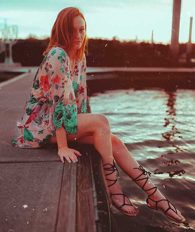 woman sitting near body of water with here strappy sandals | Strappy Sandals For Your Cute Laidback Outfits